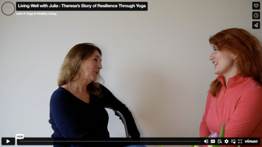 Two women sitting and smiling at each other during an interview against a plain background.
